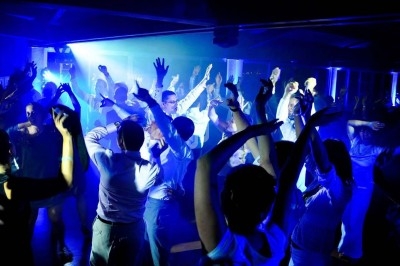 Jeux de lumières colorées projetés dans une salle avec sol en carreaux et murs en pierre.