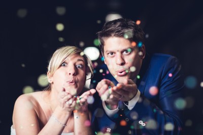 Miniature Hadrien Brunner Photographe #5 Une femme en robe blanche et talons pose son pied sur un ballon de football sur une pelouse.