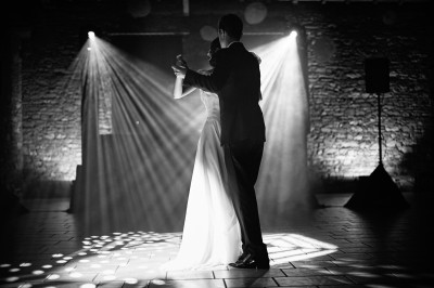 Miniature Hadrien Brunner Photographe #15 Une femme en robe blanche et talons pose son pied sur un ballon de football sur une pelouse.