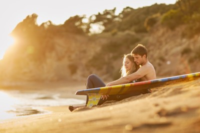 Miniature Hadrien Brunner Photographe #18 Une femme en robe blanche et talons pose son pied sur un ballon de football sur une pelouse.