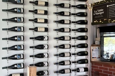 Quatre verres alignés sur une table noire avec des couverts, des plantes décoratives et une vue sur l'extérieur.