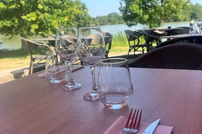 Quatre verres alignés sur une table noire avec des couverts, des plantes décoratives et une vue sur l'extérieur.