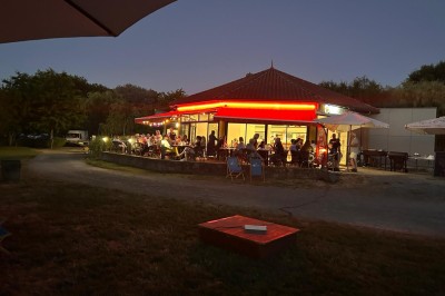 Quatre verres alignés sur une table noire avec des couverts, des plantes décoratives et une vue sur l'extérieur.