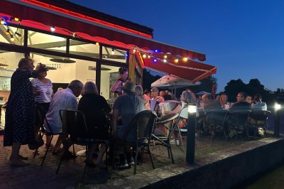 Quatre verres alignés sur une table noire avec des couverts, des plantes décoratives et une vue sur l'extérieur.