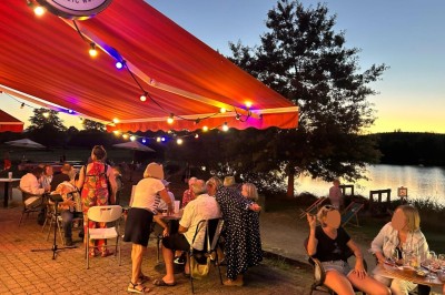 Quatre verres alignés sur une table noire avec des couverts, des plantes décoratives et une vue sur l'extérieur.