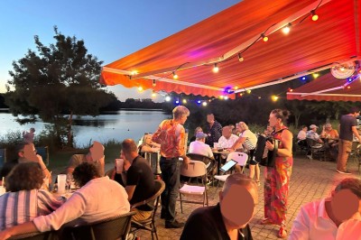 Quatre verres alignés sur une table noire avec des couverts, des plantes décoratives et une vue sur l'extérieur.