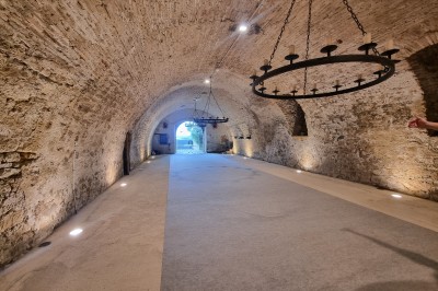 Miniature Location salle Saint-Félix-Lauragais (Haute-Garonne) - La Commanderie #2 Portail métallique noir fermé entre deux murs en pierre, entouré de végétation et d'arbustes.