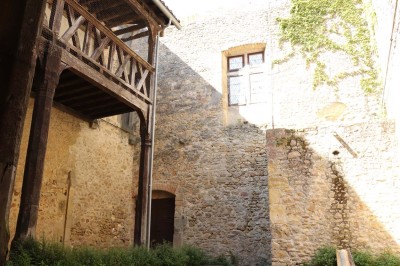 Miniature Location salle Saint-Félix-Lauragais (Haute-Garonne) - La Commanderie #8 Portail métallique noir fermé entre deux murs en pierre, entouré de végétation et d'arbustes.