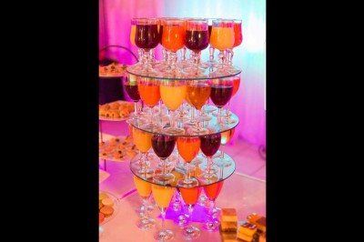 Assiette contenant un morceau de viande avec sauce, légumes rôtis, chips croustillante et garniture verte.