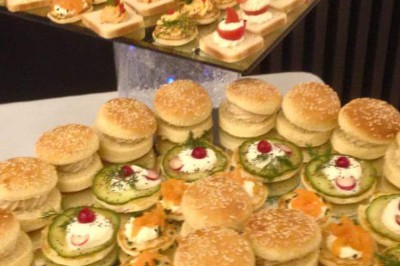 Assiette contenant un morceau de viande avec sauce, légumes rôtis, chips croustillante et garniture verte.