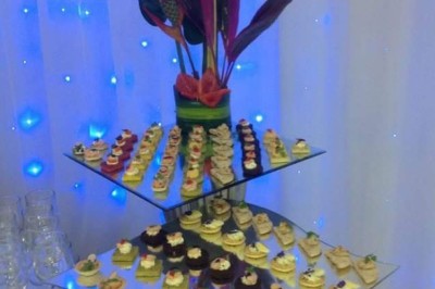 Assiette contenant un morceau de viande avec sauce, légumes rôtis, chips croustillante et garniture verte.