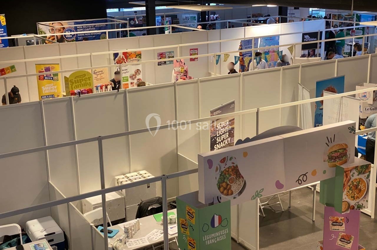 Vue d'un salon professionnel avec des stands exposant des produits alimentaires et des affiches promotionnelles.