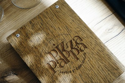 Miniature Location salle Voisins-le-Bretonneux (Yvelines) - Pizza Pappa #8 Piles de boîtes à pizza orange empilées, avec un logo, des illustrations et un numéro de téléphone imprimés.