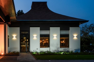 Salle de conférence avec des rangées de chaises colorées face à un écran de projection allumé.