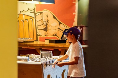 Salle de conférence avec des rangées de chaises colorées face à un écran de projection allumé.