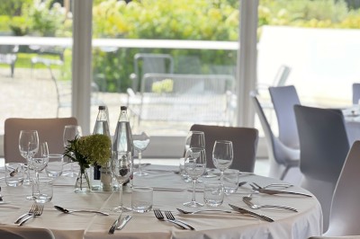 Salle de conférence avec des rangées de chaises colorées face à un écran de projection allumé.