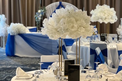 Salle de conférence avec des rangées de chaises colorées face à un écran de projection allumé.