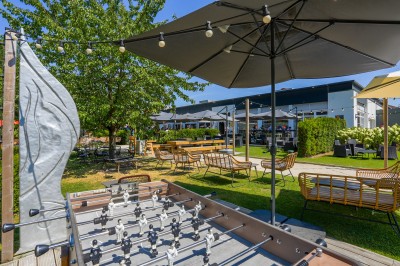 Salle de conférence avec des rangées de chaises colorées face à un écran de projection allumé.