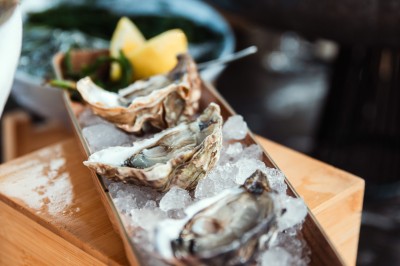 Salle de conférence avec des rangées de chaises colorées face à un écran de projection allumé.