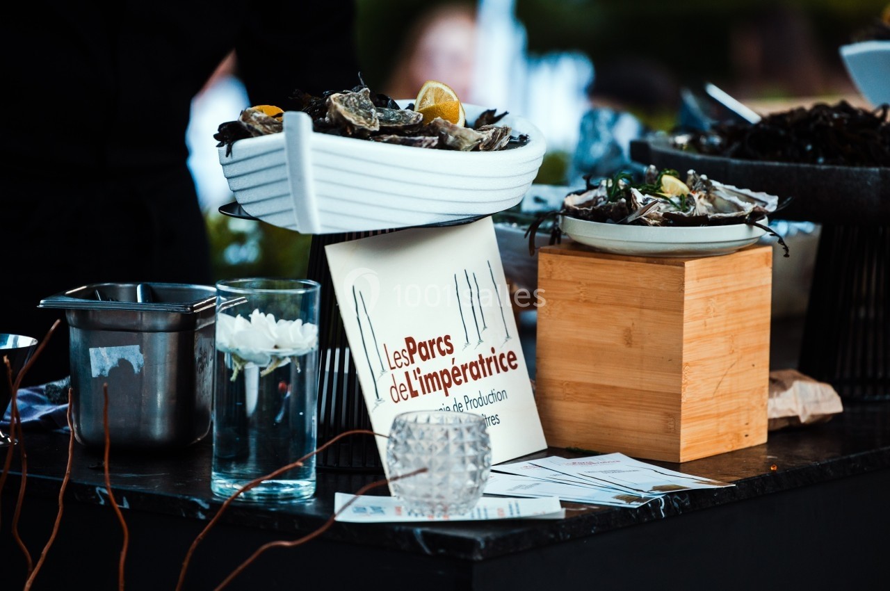 Plateau d'huîtres présenté sur une table avec un panneau indiquant ’Les Parcs de l'Impératrice’.