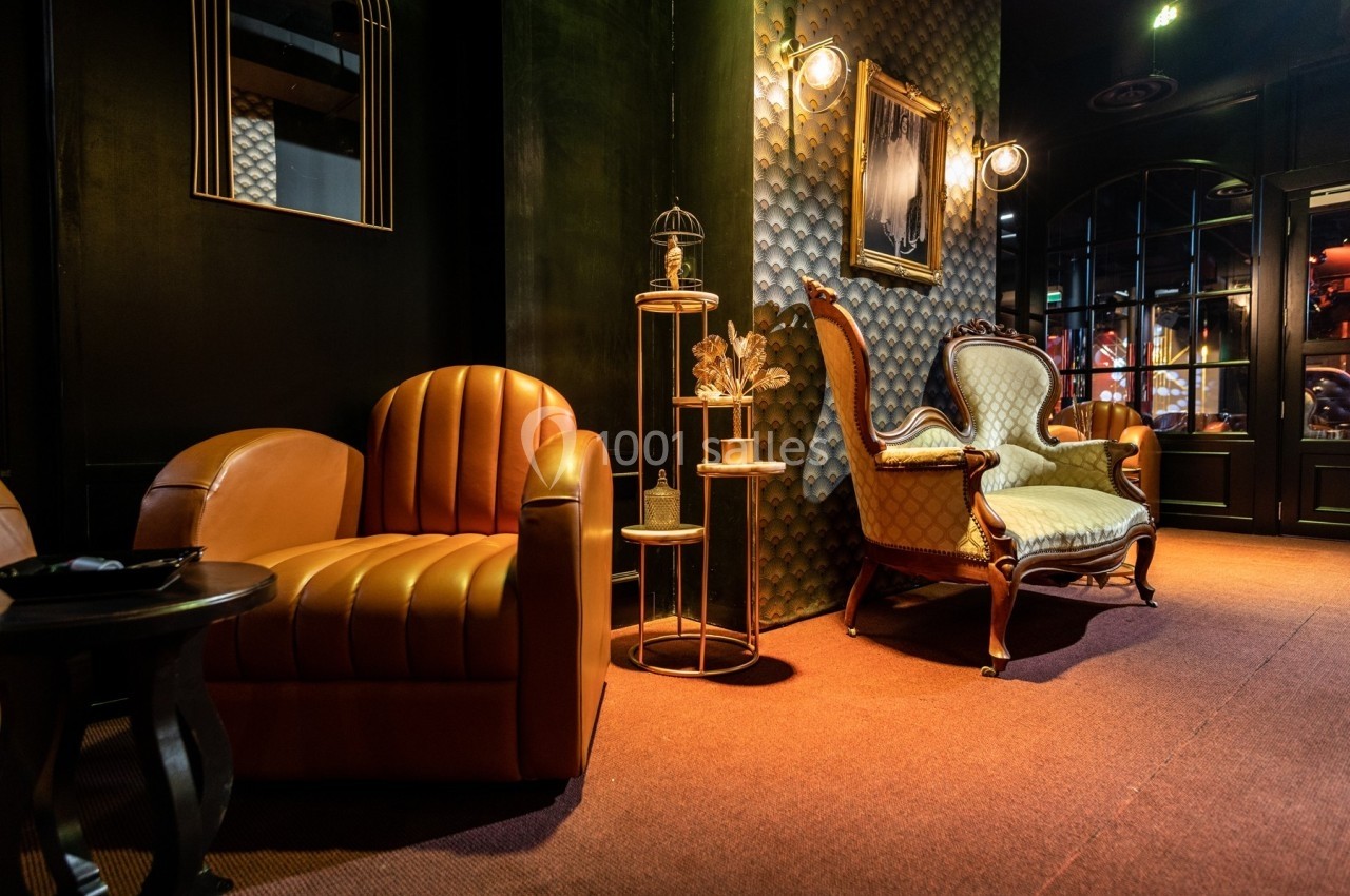 Fauteuils en cuir et en bois dans un salon décoré de lampes murales et d'un mur texturé.