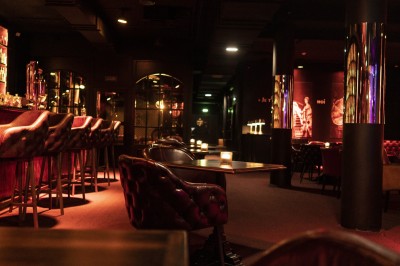 Canapé en cuir beige dans une pièce tamisée, avec un avis de recherche encadré accroché au mur.