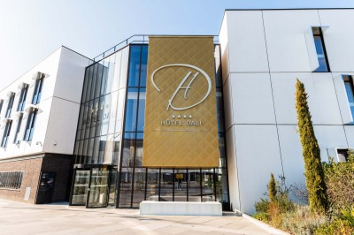 Canapé en cuir beige dans une pièce tamisée, avec un avis de recherche encadré accroché au mur.