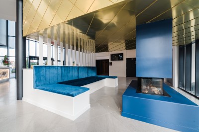 Canapé en cuir beige dans une pièce tamisée, avec un avis de recherche encadré accroché au mur.