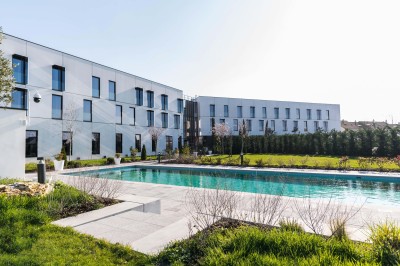 Canapé en cuir beige dans une pièce tamisée, avec un avis de recherche encadré accroché au mur.