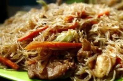 Tranches d'ananas caramélisées disposées sur un plat blanc, décorées de feuilles de menthe fraîche.