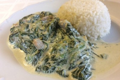 Tranches d'ananas caramélisées disposées sur un plat blanc, décorées de feuilles de menthe fraîche.