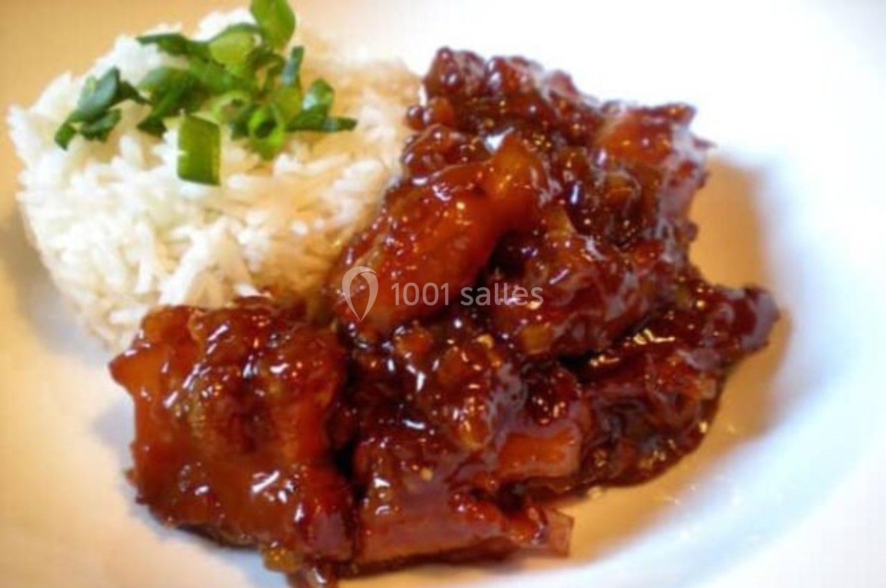 Plat de poulet caramélisé accompagné de riz blanc garni de ciboulette, présenté sur une assiette blanche.
