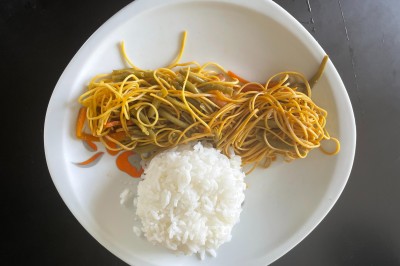 Tranches d'ananas caramélisées disposées sur un plat blanc, décorées de feuilles de menthe fraîche.
