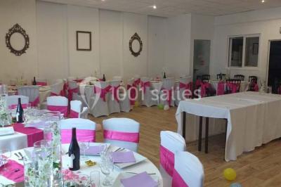 Espace extérieur décoré de tapis, lanternes et coussins, avec une table dressée en arrière-plan.