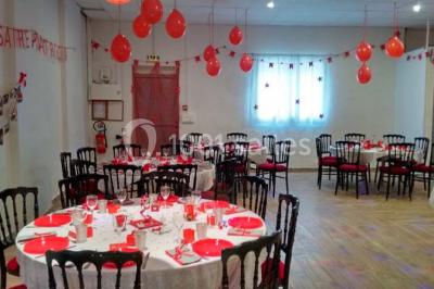 Espace extérieur décoré de tapis, lanternes et coussins, avec une table dressée en arrière-plan.