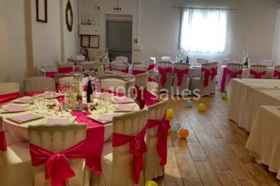 Espace extérieur décoré de tapis, lanternes et coussins, avec une table dressée en arrière-plan.