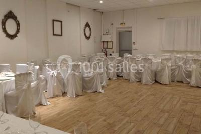 Espace extérieur décoré de tapis, lanternes et coussins, avec une table dressée en arrière-plan.