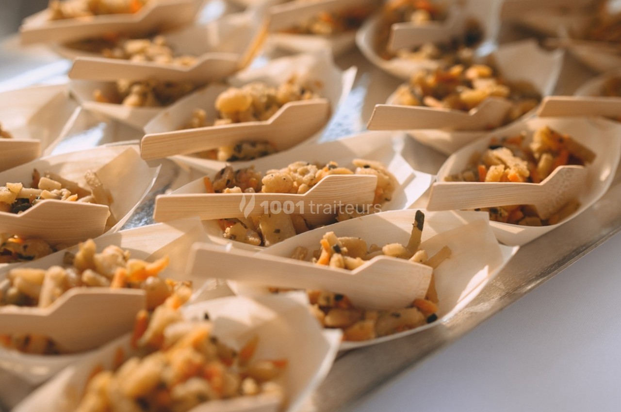 Portions individuelles de salade de pâtes aux légumes servies dans des coupelles en bois avec des mini-fourchettes.