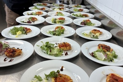 Dessert composé d'un gâteau au chocolat avec une garniture blanche et d'une boule de glace sur un lit de crumble.