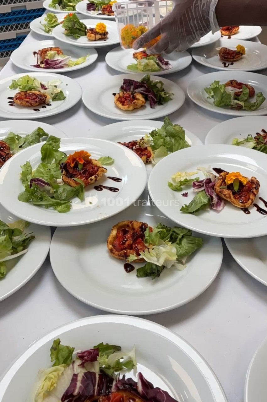Assiettes dressées avec des tartelettes aux légumes, salade verte et filet de sauce balsamique, prêtes à être servies.