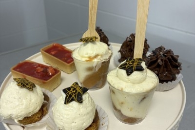 Dessert composé d'un gâteau au chocolat avec une garniture blanche et d'une boule de glace sur un lit de crumble.