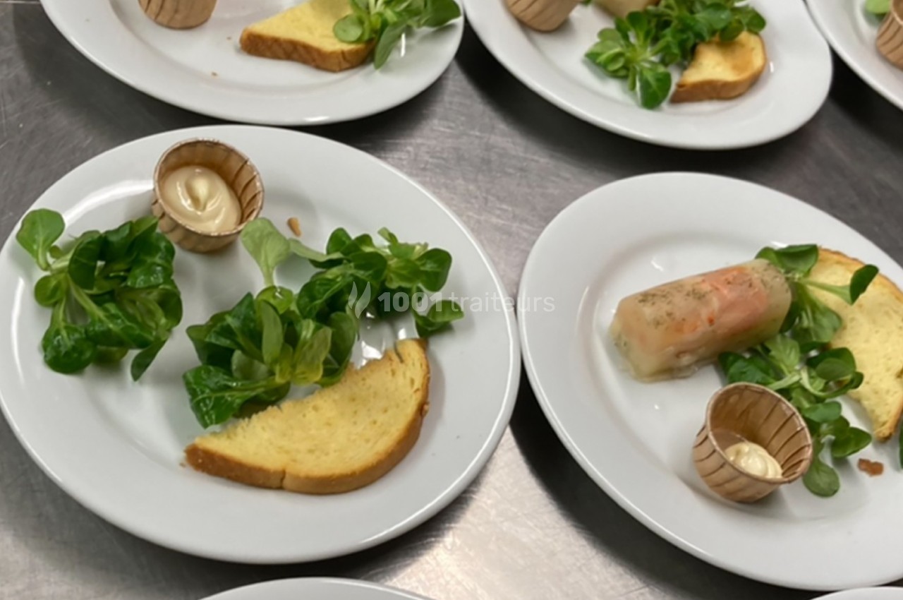 Assiettes contenant de la mâche, une tranche de pain, une sauce en pot et un rouleau de printemps.