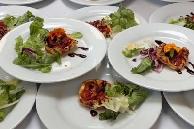 Dessert composé d'un gâteau au chocolat avec une garniture blanche et d'une boule de glace sur un lit de crumble.