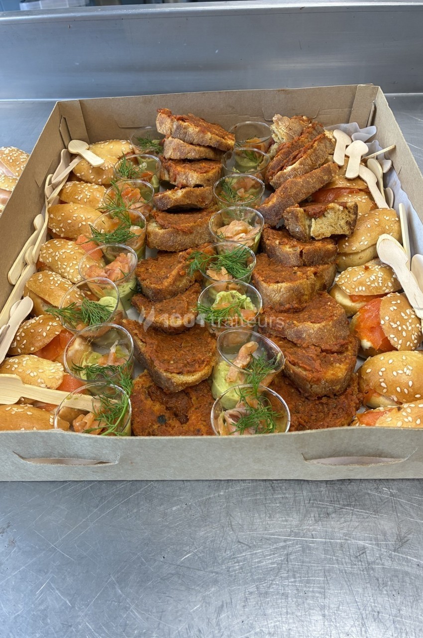 Plateau de mini-burgers au saumon et verrines garnies, présenté avec des couverts en bois.