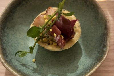 Dessert composé d'un gâteau au chocolat avec une garniture blanche et d'une boule de glace sur un lit de crumble.