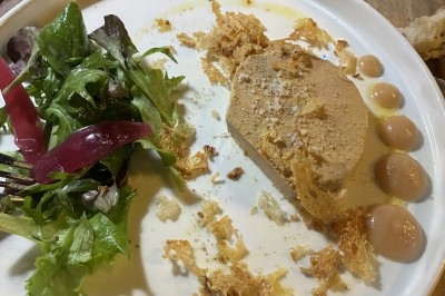 Dessert composé d'un gâteau au chocolat avec une garniture blanche et d'une boule de glace sur un lit de crumble.
