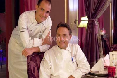 Sculpture moderne d'un taureau noir aux cornes longues et rouges, avec une posture dynamique et stylisée.