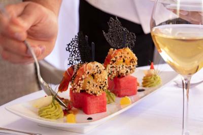 Sculpture moderne d'un taureau noir aux cornes longues et rouges, avec une posture dynamique et stylisée.