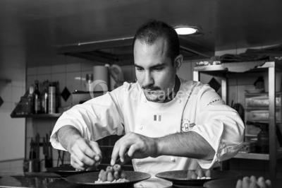 Sculpture moderne d'un taureau noir aux cornes longues et rouges, avec une posture dynamique et stylisée.