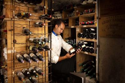 Sculpture moderne d'un taureau noir aux cornes longues et rouges, avec une posture dynamique et stylisée.
